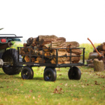 Gorilla utility cart filled with logs, featuring black metal frame and off-road tires.