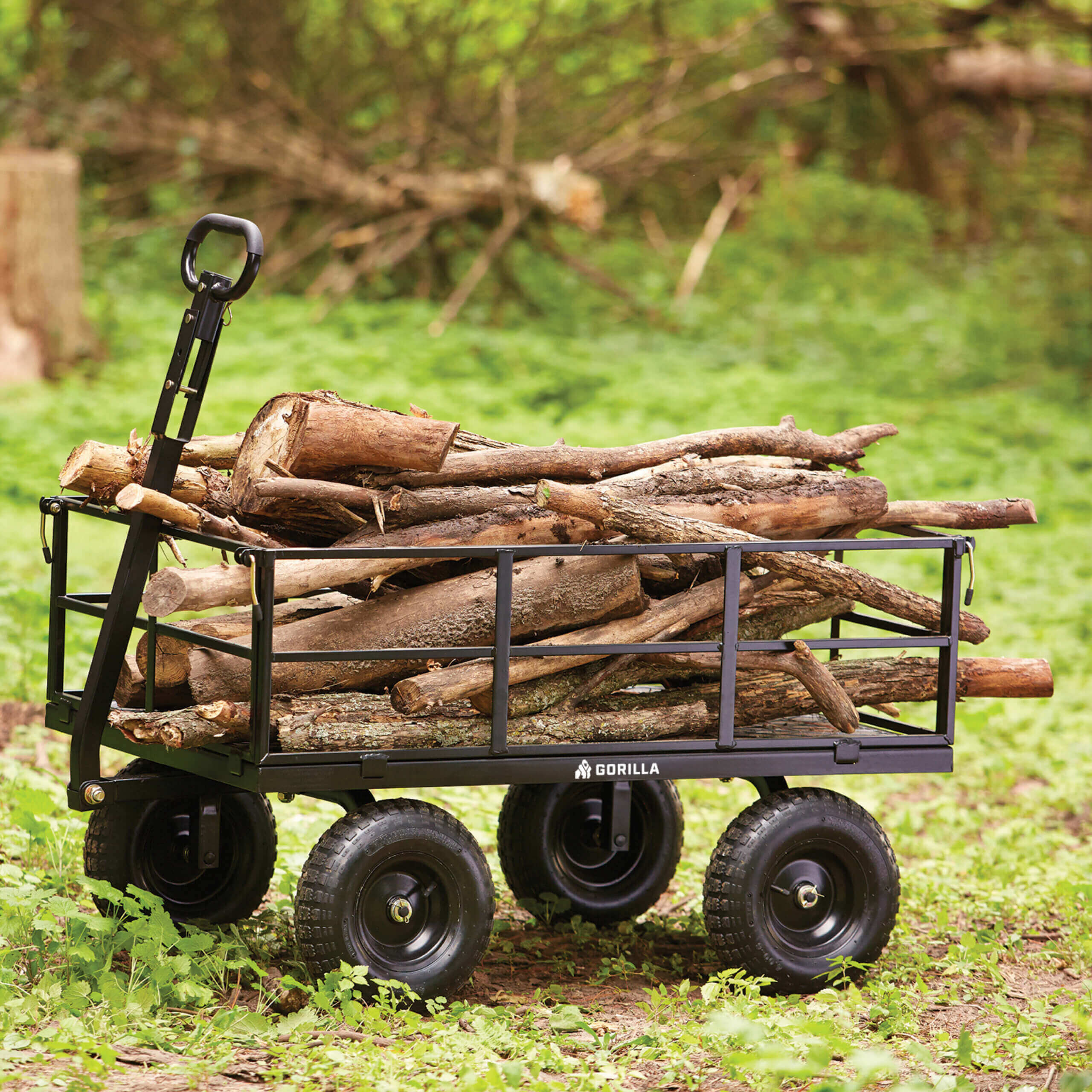 Gorilla heavy-duty black cart loaded with logs, in a grassy outdoor setting.
