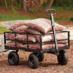 Black Gorilla cart carrying multiple bags of mulch on a natural outdoor surface.