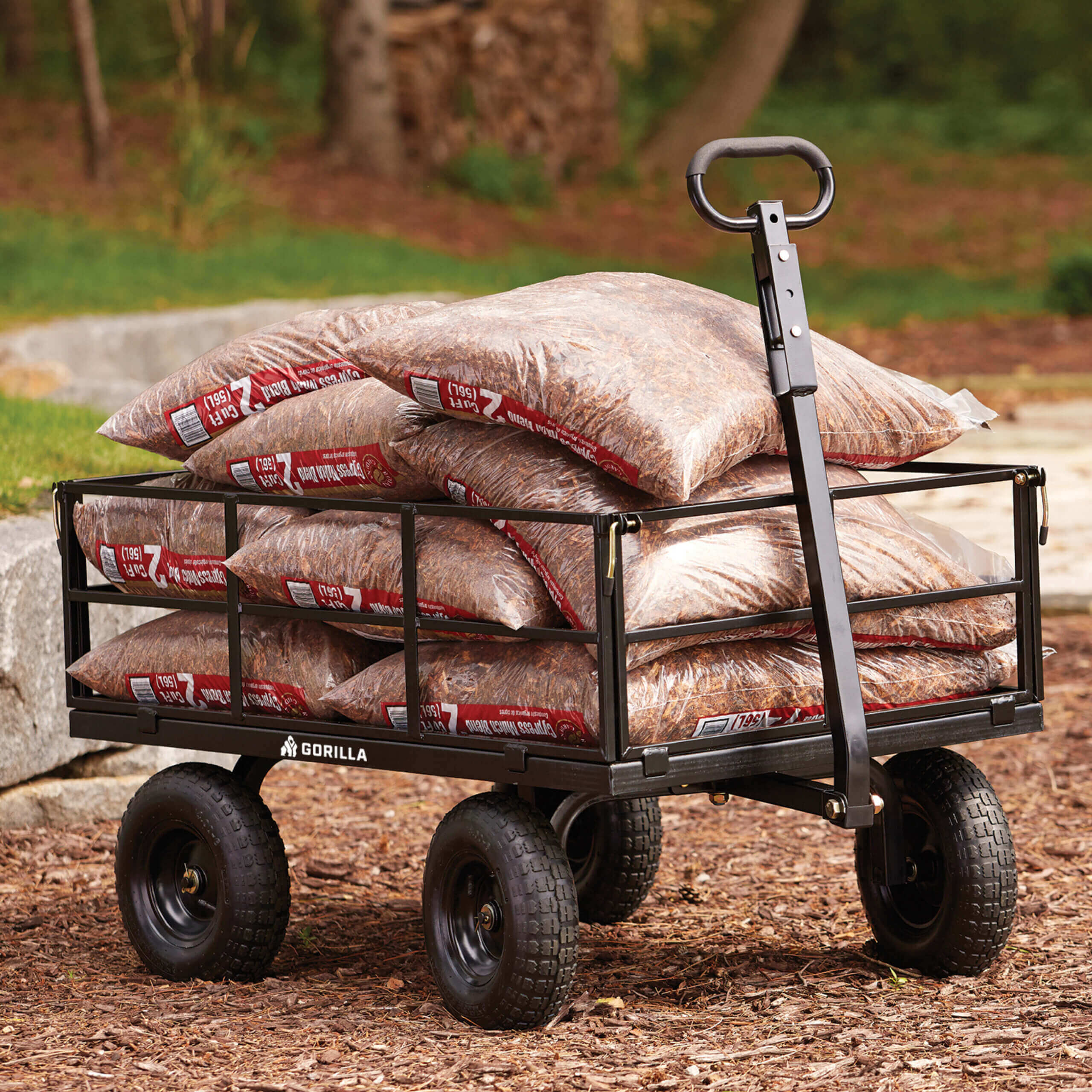 Black Gorilla cart carrying multiple bags of mulch on a natural outdoor surface.