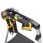 Tool storage tray on a ladder holding screws, a drill, a hammer, and a tape measure.
