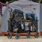 Black Gorilla utility cart loaded with camping gear in front of a gray tent.