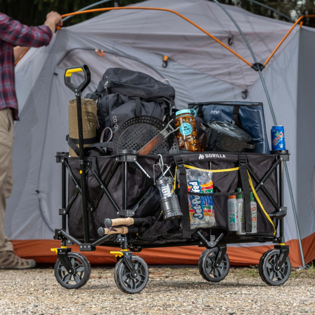 Black Gorilla utility cart loaded with camping gear in front of a gray tent.