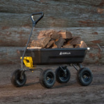 Black Gorilla utility cart loaded with firewood on a dirt surface.