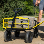 Outdoor heavy-duty cart with yellow frame carrying stone blocks on dirt path.