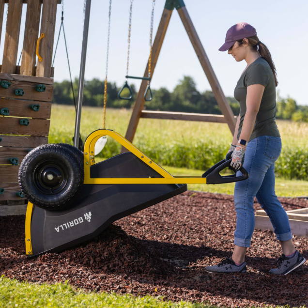 Person using a Gorilla Made utility cart with a yellow frame and black tires.