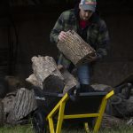 man placing a wood log into a GCR-7