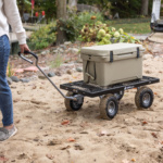A person pulls a black Gorilla cart on sand, carrying a beige cooler labeled "ENGEL."
