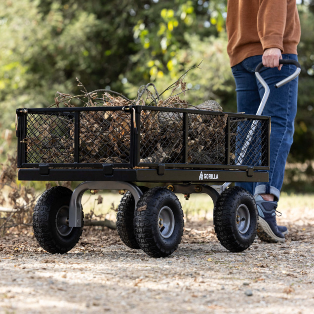 Black Gorilla utility cart loaded with branches on gravel path.
