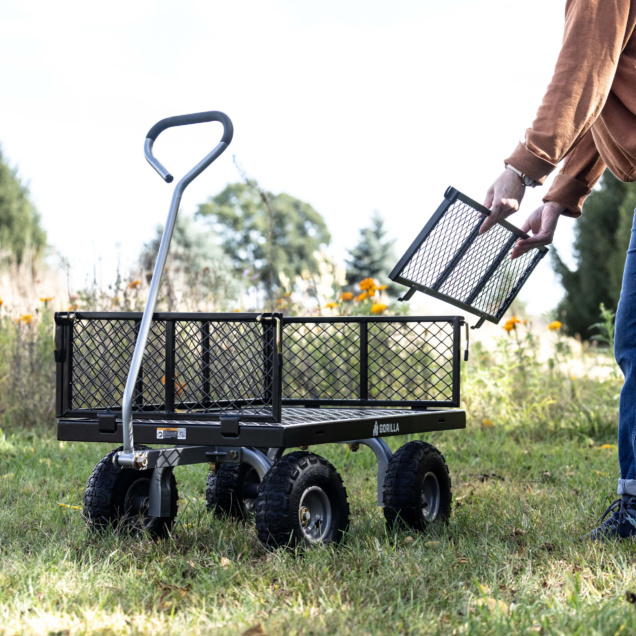 Black Gorilla utility cart on grass with removable metal side panel.