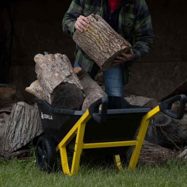 Gorilla Made cart with yellow frame loaded with logs, person adding another piece.