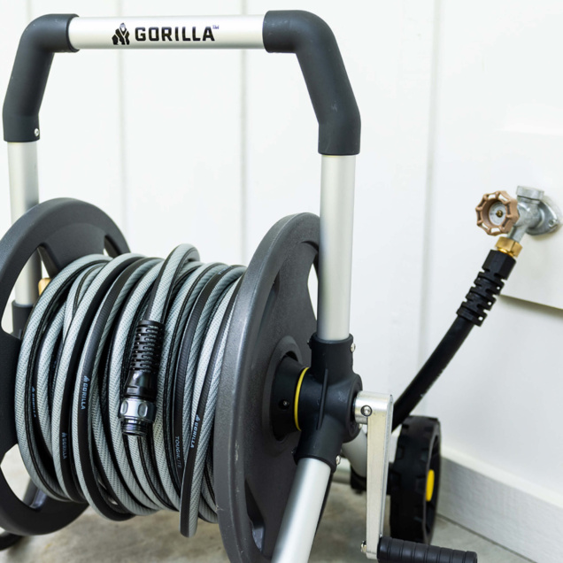 Gorilla hose reel with gray hose, black handle, connected to faucet.