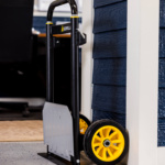 Gorilla Made hand truck with black frame, silver plate, and yellow wheels.