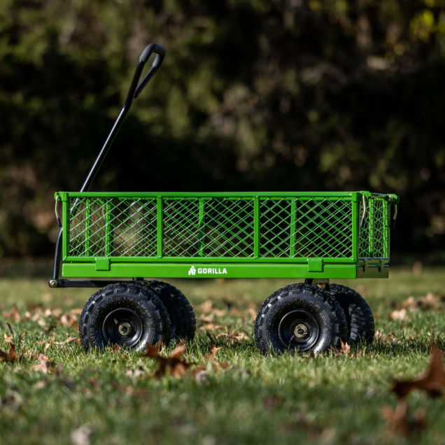 Green Gorilla utility cart with thick black wheels on grass, ideal for tough tasks.