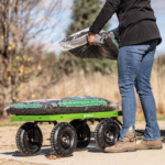Person loading bags of "Dark Brown Majestic Mulch" onto a green Gorilla utility cart.