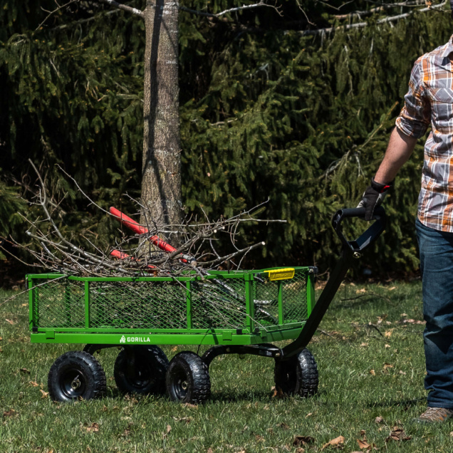 Green Gorilla Made cart with branches and tools, on grass.
