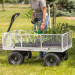 Person with plants in heavy-duty Gorilla Made metal mesh cart on grass.