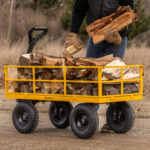 Yellow Gorilla cart loaded with firewood, handle gripped by a person.