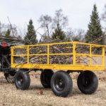 Yellow Gorilla utility cart loaded with branches, hitched to an ATV.