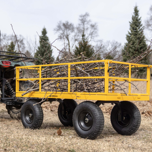 Yellow Gorilla utility cart loaded with branches, hitched to an ATV.