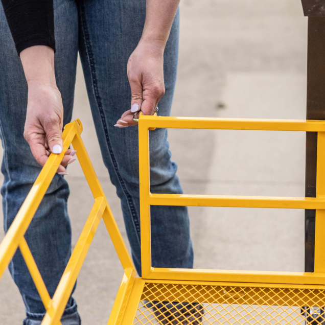 Hands assembling a bright yellow utility cart from Gorilla Made.