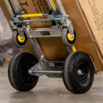 Heavy-duty hand truck with yellow accents, supporting a large cardboard box.