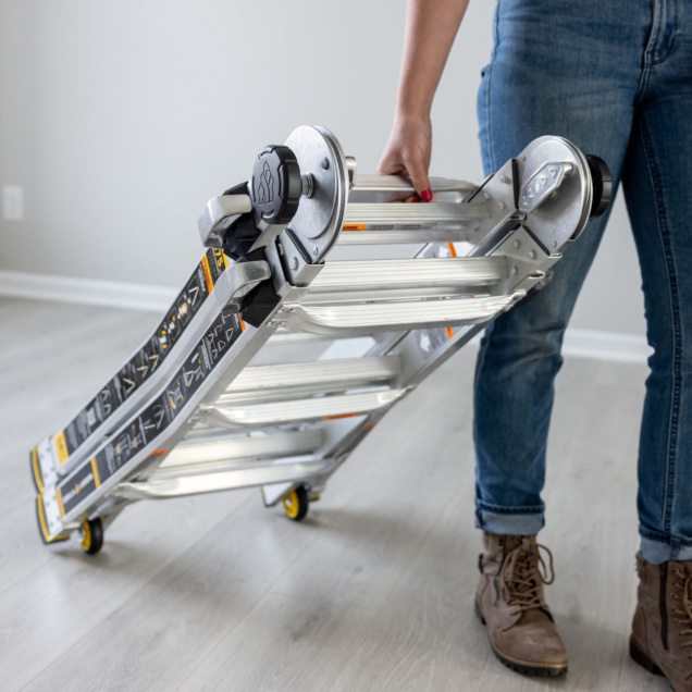 Person holding folded Gorilla Made aluminum ladder with black and orange accents.