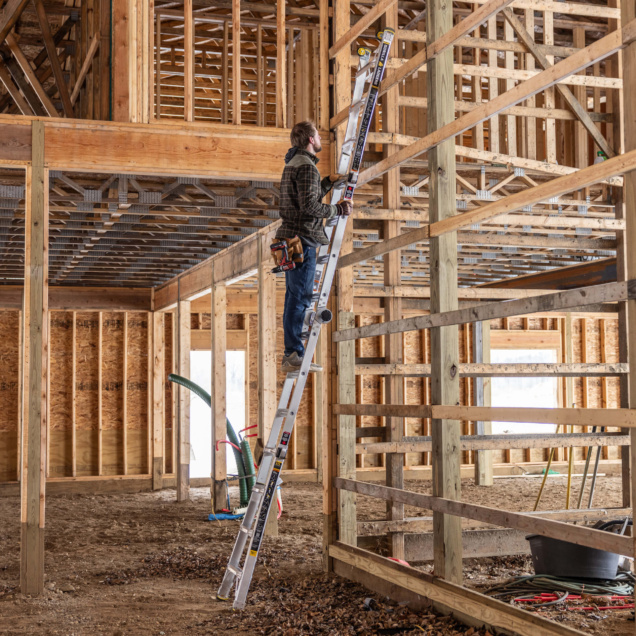 Person on Gorilla Made ladder in a wooden construction site.