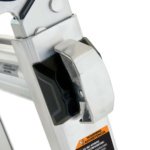 Close-up of a metal ladder hinge with warning label. Text: "WARNING ADVERTENCIA."