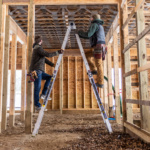 Two people working on a wooden frame using a Gorilla Made ladder.