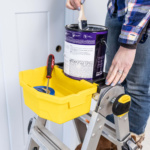 Gorilla Made ladder with yellow utility tray holding paint supplies and a paint can.