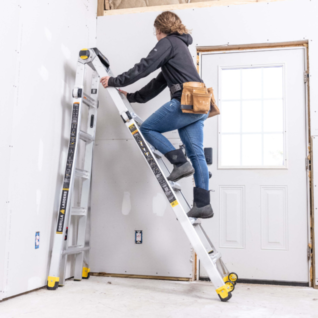 Person using a Gorilla Ladders extension ladder indoors near a white door.
