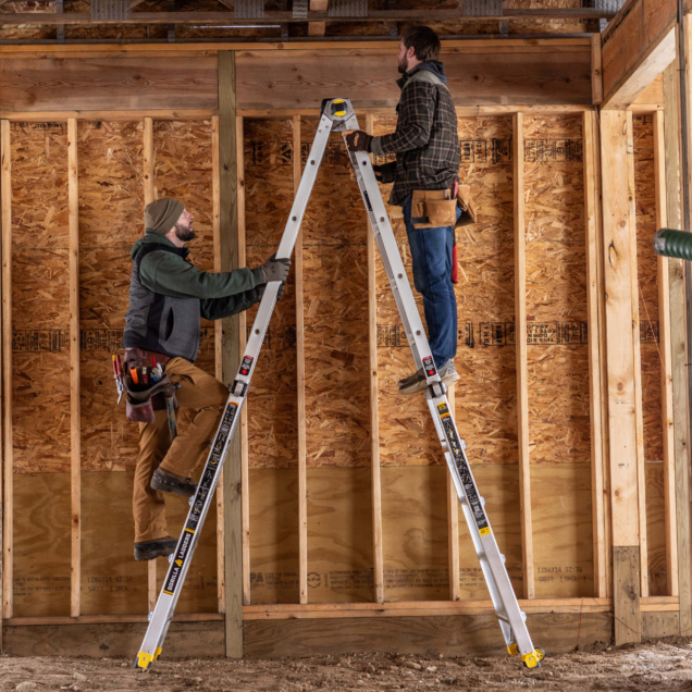 Two people working with a Gorilla Made ladder in a wooden construction site.