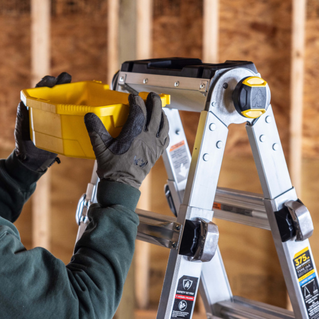 Person places yellow tool tray on Gorilla Made ladder. "375 lbs" label visible.