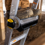Close-up of Gorilla Made ladder step with boots on, featuring silver and yellow details.