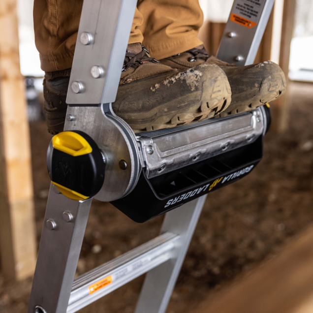 Close-up of Gorilla Made ladder step with boots on, featuring silver and yellow details.