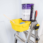 Yellow utility tray on ladder with paint can and tools; part of Gorilla Made products.