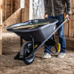 Black Gorilla Made wheelbarrow carrying wooden planks in a construction area.