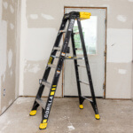 Gorilla Made GF300 black ladder with yellow accents, 300 lb capacity, indoors.