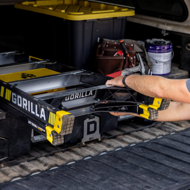 Gorilla Made GF300 ladder with yellow accents being loaded into a vehicle.