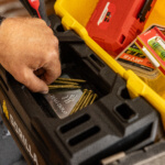 Hand using a Mag-Hold in a Gorilla Made tool box with assorted screws and tools.