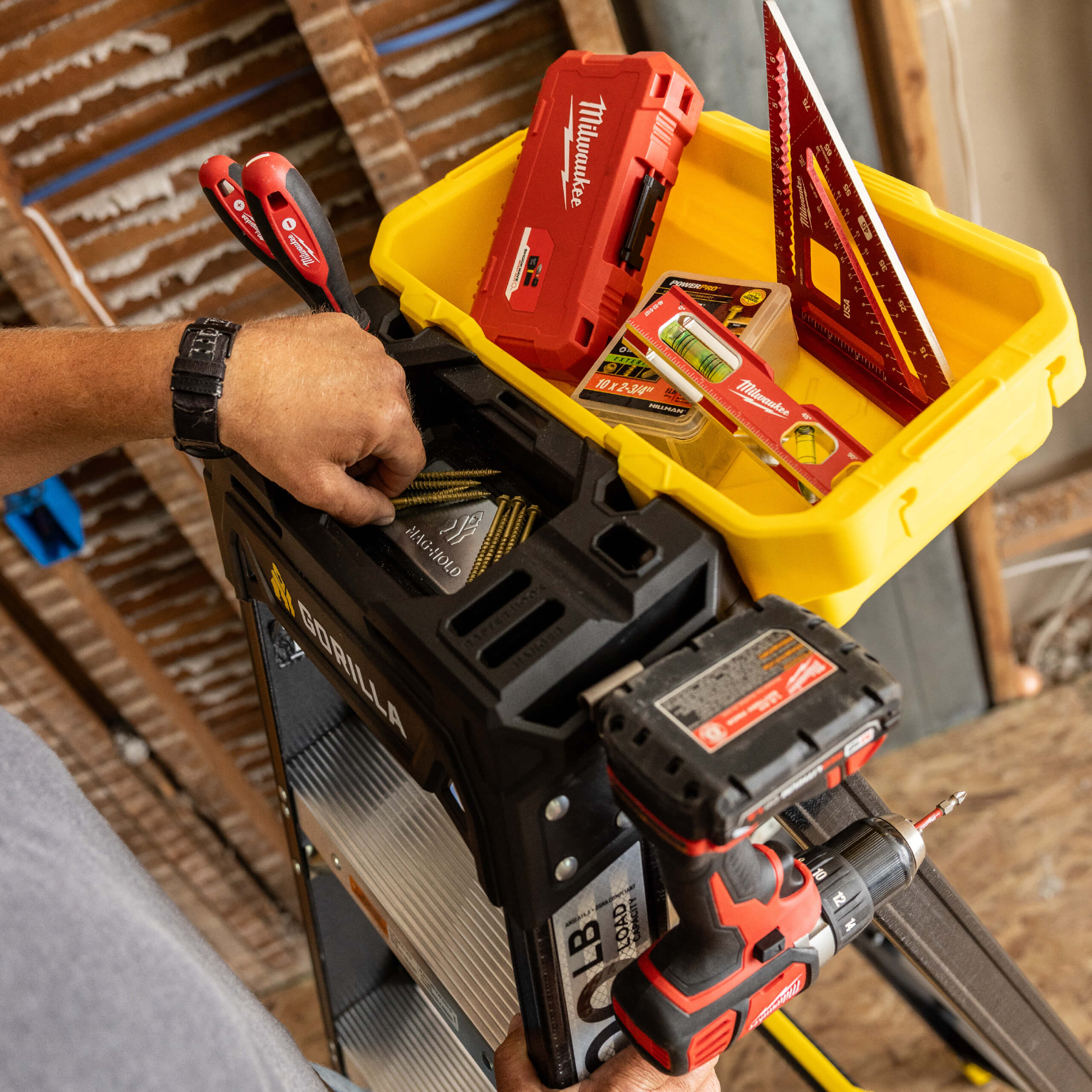 Gorilla Made ladder with tools in a yellow container and a power drill, indoors.