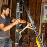 Person using a Gorilla Made ladder marked "300 LB LOAD" in a construction setting.