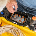 Person organizing connectors in a yellow and black utility cart with text "TAG-HOLD".