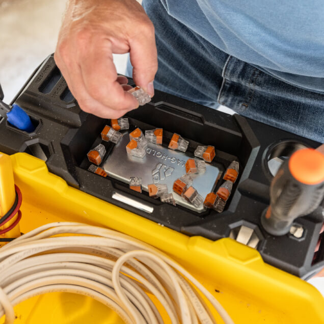 Person organizing connectors in a yellow and black utility cart with text "TAG-HOLD".