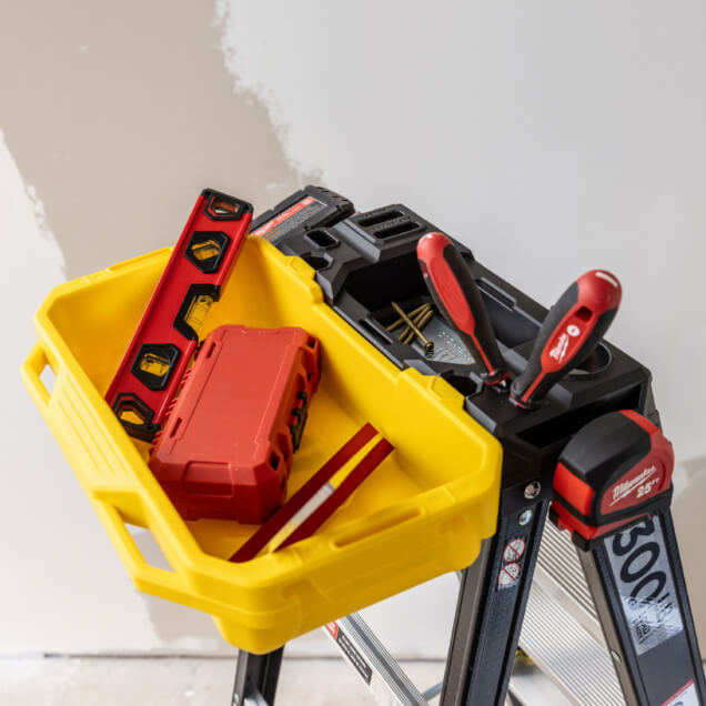Yellow toolbox on GF300 ladder with red and black tools, screws, and level.