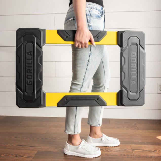 Person holding a black and yellow Gorilla ladder rail.