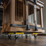 Heavy-duty wooden cage on a Gorilla Made cart with black and yellow wheels.