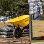 Yellow Gorilla Made wheelbarrow on a trailer with black mulch bags.