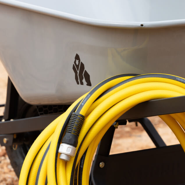 Gray wheelbarrow with Gorilla ToughLite PRO hose coiled on handle.